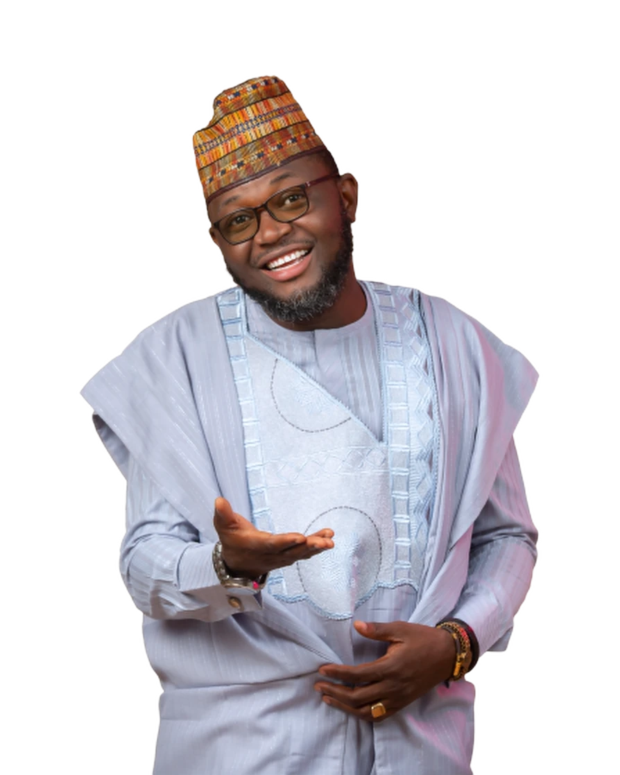 Alhaji Shehu smiling in a light blue agbada and patterned cap