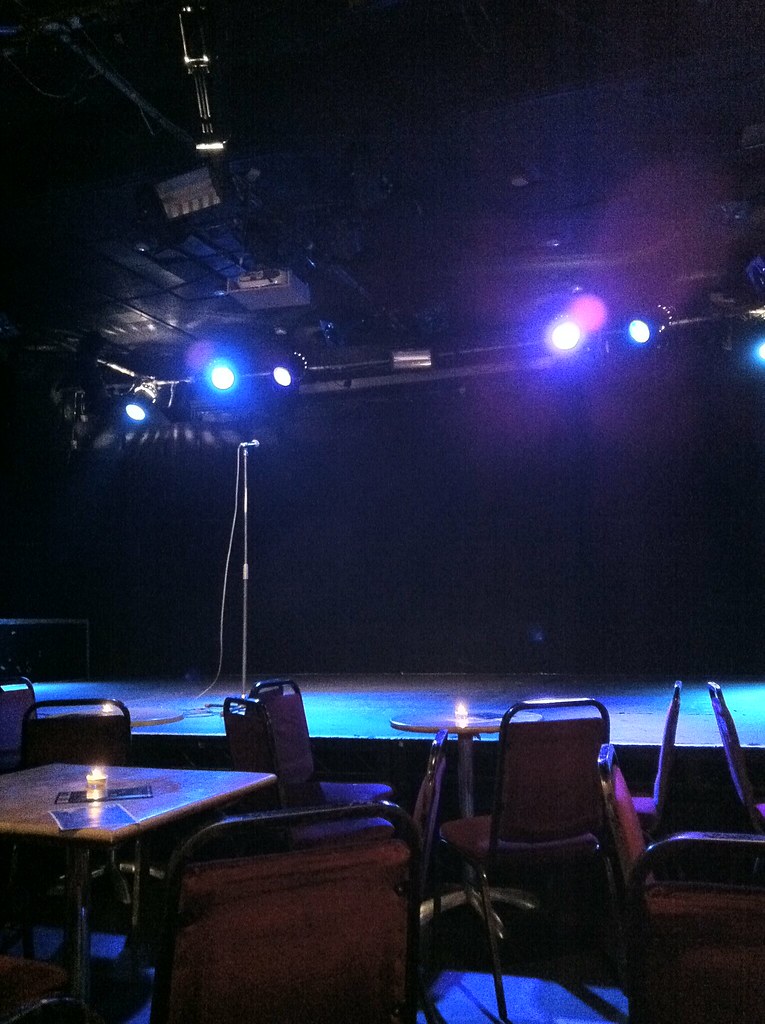 A microphone on a comedy stage under spotlights